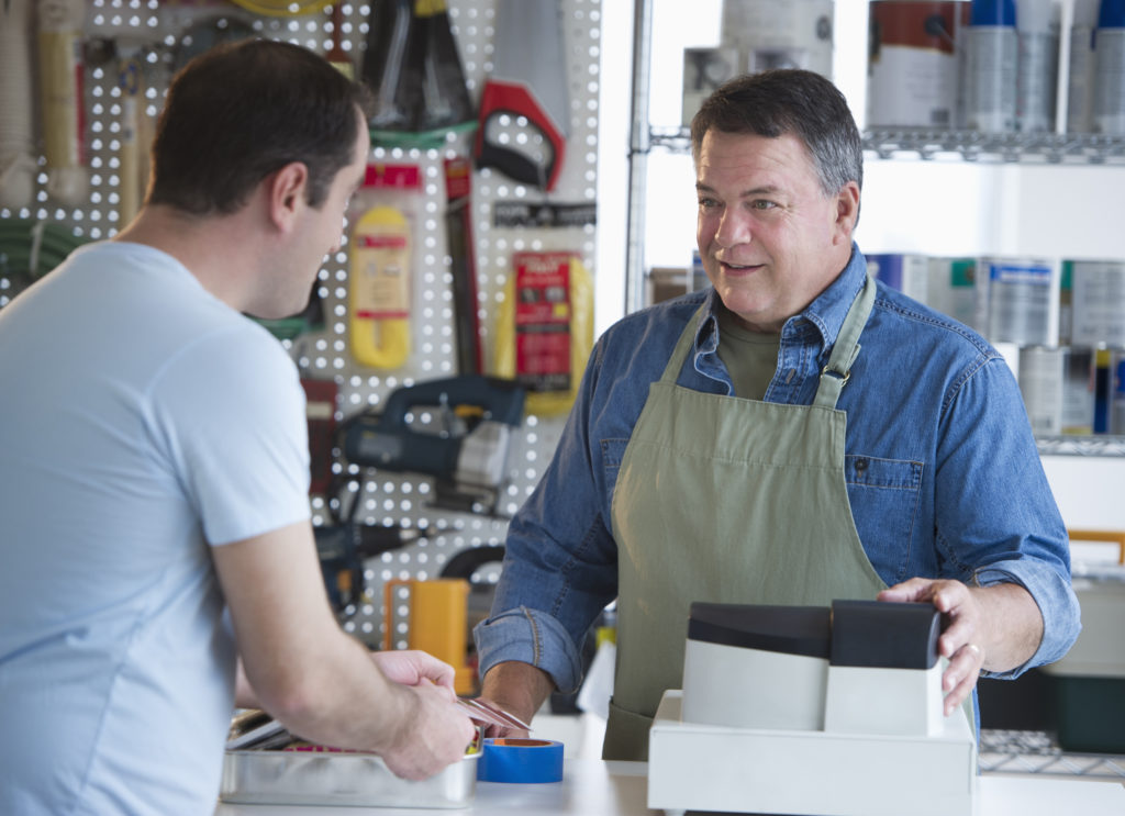 Service owner. Household shop. The seller in the Hardware Store gives a loan. Shop owner.